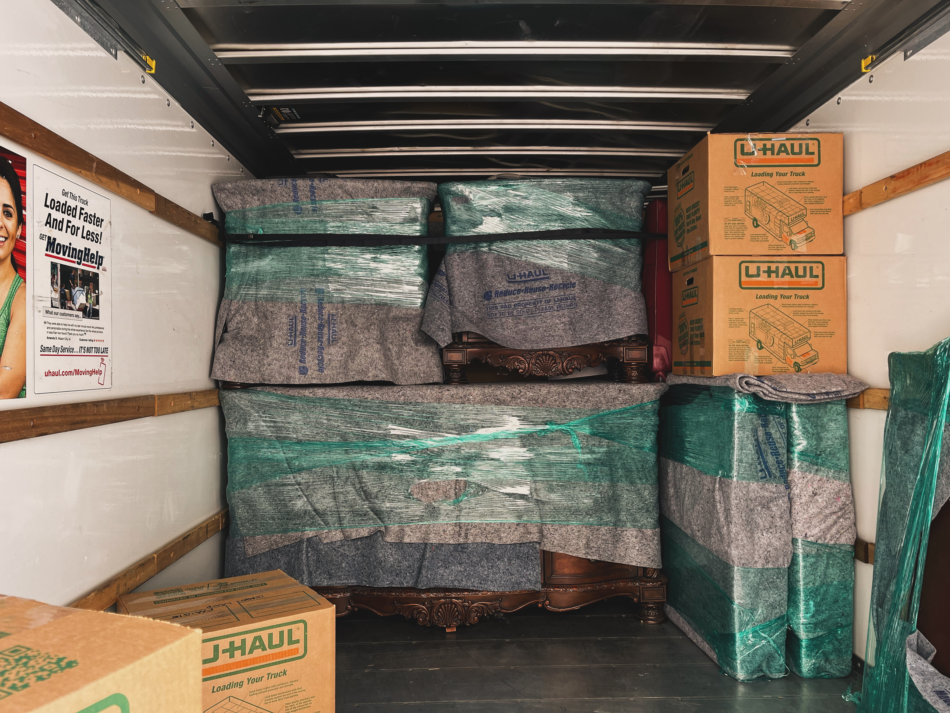 two men moving couch into uhaul